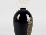 a black vase with a white flower on top of it