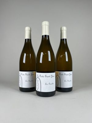 trois bouteilles de vin posées sur une table l'une à côté de l'autre
