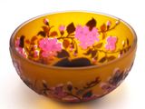 a yellow bowl with pink flowers in it on a white surface