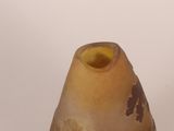 a brown vase with a yellow top sitting on a table