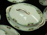 many plates and bowls on a table with a gold handle