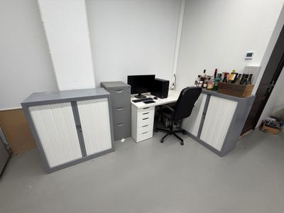 une pièce équipée d'un bureau, d'armoires et d'un ordinateur posé dessus