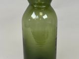 un vase en verre vert posé sur une table