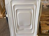 a white dishwasher sitting on the floor in a warehouse