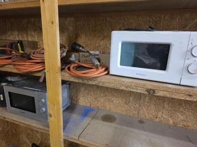 un micro-ondes et un four à micro-ondes posés sur une étagère dans une pièce