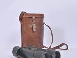 an old pair of binoculars sitting on top of a brown case