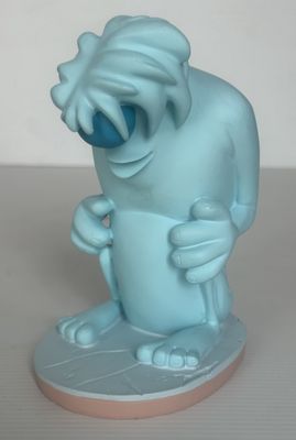 une statue bleue représentant un personnage de dessin animé, posée sur une assiette