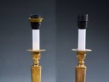 a pair of brass candles with white candlesticks and black candlesticks