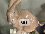 a rabbit figurine on display in a glass case