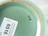 a close up of a green vase with a tag on it