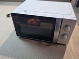 a microwave that is sitting on the floor next to a door