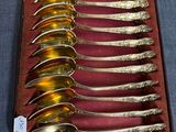 six cuillères en argent dans une boîte posée sur une table