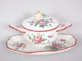 a white bowl and saucer with a bird on top of it