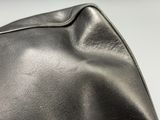 a close up of a black leather bag on a table