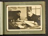 a black and white photo of two men sitting at a desk