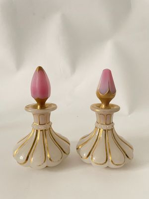 une paire de bougeoirs roses et dorés sur fond blanc