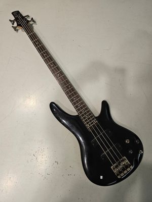 une guitare basse noire posée sur une table