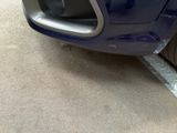 a close up of a car ' s front bumper with a flat tire