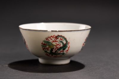 un bol blanc orné d'un dragon, posé sur une table