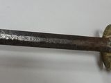a close up of a sword on a white surface