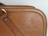 a brown leather bag with a brown strap on it