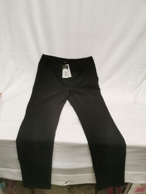 Le pantalon est noir et comporte une étiquette blanche.