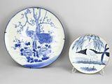 two blue and white plates and a plate with a bird on it