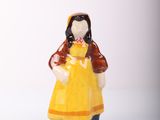 a small figurine of a woman in a yellow dress