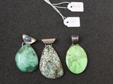 three pendants of different colors and shapes on a black surface