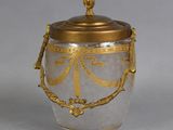 a silver and gold vase with a gold lid