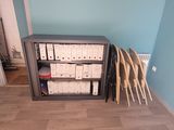 a room with a bookcase and several chairs in it