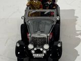 two men riding in a toy car on a white surface