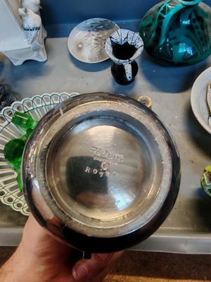 une personne tenant un bol en argent devant un plateau de plats