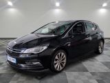 L'Opel noire est garée dans une grande pièce au sol carrelé en damier.