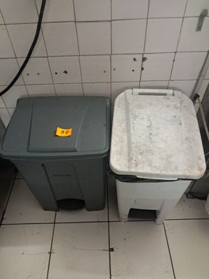 deux poubelles placées l'une à côté de l'autre dans une salle de bains