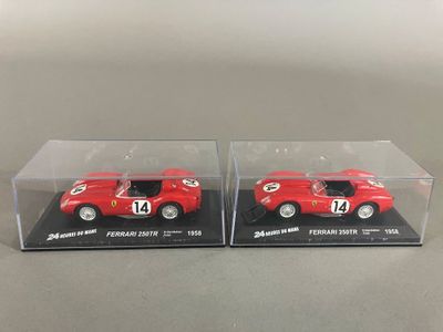 deux petites voitures rouges dans des boîtes transparentes posées sur une table