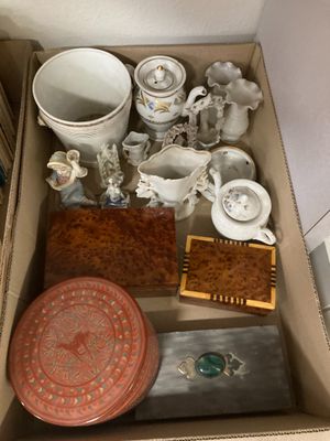 une boîte remplie d'objets divers, posée par terre