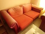 a red couch and a coffee table in a living room