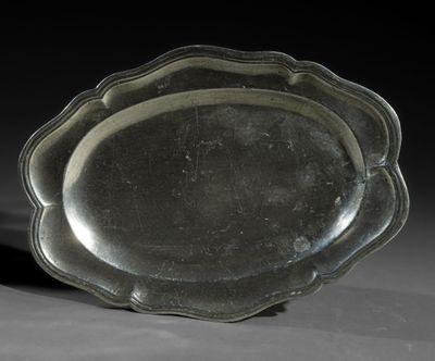a silver plate with a scallop edge on a table