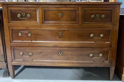 une commode en bois surmontée d'un miroir