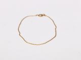 a gold chain bracelet with a tiny heart on it