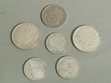 six different british coins sitting on top of each other on a table