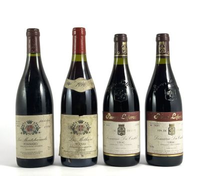 quatre bouteilles de vin sont alignées sur une surface blanche