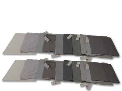 six morceaux de tissu pliés sur une surface blanche
