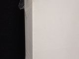 a picture of a white refrigerator in a black room