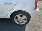 a white car parked on a gravel lot next to a parking meter