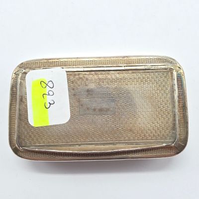 une assiette en argent sur laquelle est collé un autocollant jaune