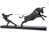 statue of a man pulling a bull with a rope