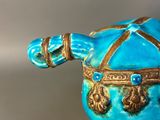 a blue and gold figurine of a horse on a table