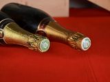 two bottles of champagne sitting on a red table
